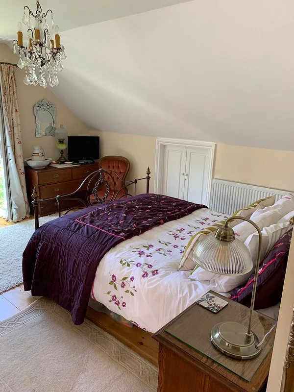 King-size master bedroom with armchair, television and fitted storage
