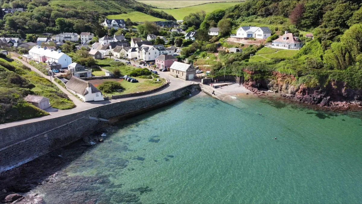 Aerial view of Inner Hope, with village houses around the clear turquoise cove