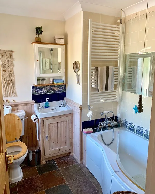 Bathroom with a whirlpool bath, shower, basin and heated towel rail