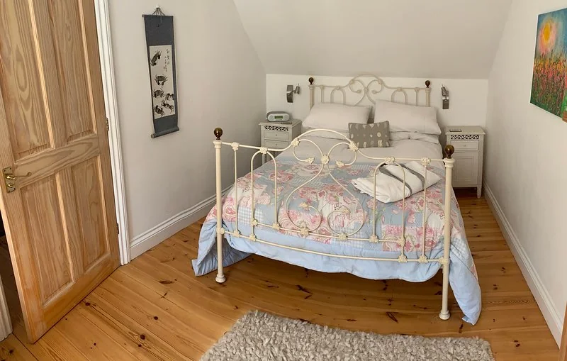 Double bedroom with an iron bed and wooden floor